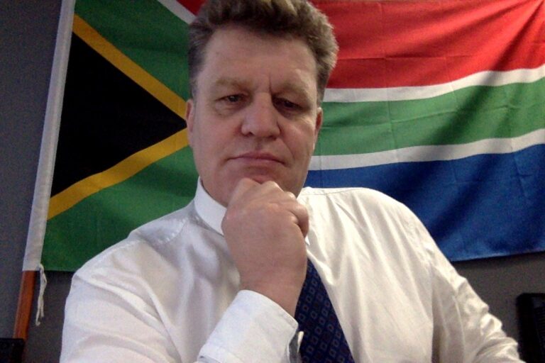 Prof. Simon Connell in front of the South African flag